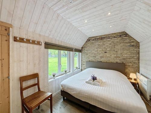 a bedroom with a large bed and a chair at Villa Sunny - Koksijde in Koksijde