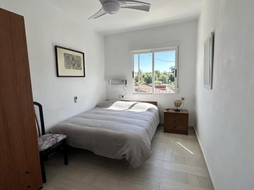 a white bedroom with a bed and a window at Alojamiento Rural Manomar in Torre de Don Miguel