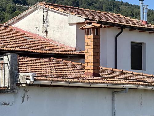 a white building with tile roofs and a window at Alojamiento Rural Manomar in Torre de Don Miguel