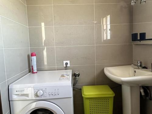 a small bathroom with a washing machine and a sink at Alojamiento Rural Manomar in Torre de Don Miguel