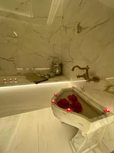 a bathroom with a sink with red roses in it at Hotel Royal ASBU Tunis in Tunis
