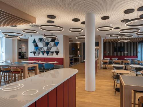 a restaurant with tables and chairs and a cafeteria at Holiday Inn Express Heilbronn by IHG in Heilbronn
