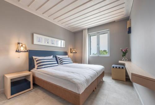 um quarto com uma cama grande e uma janela em Hapimag Resort Porto Heli em Porto Heli
