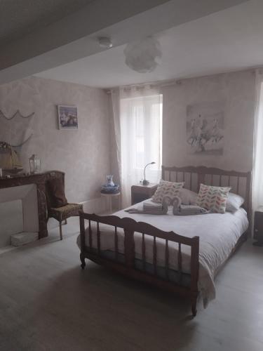 une chambre avec un grand lit et une chaise dans l'établissement jolie maison dans petit village, à Vignory