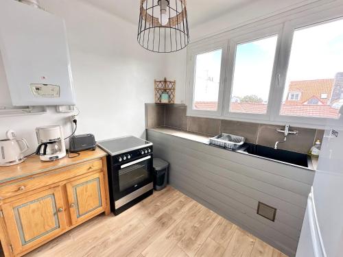 une cuisine avec un évier et une cuisinière four supérieur dans l'établissement Calme - À deux pas de la plage - 2 à 4 pers, à Berck-sur-Mer