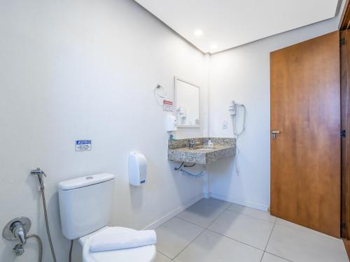 a bathroom with a toilet and a sink at Villa di Cavi Hotel in Gramado