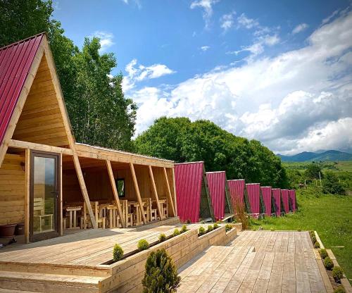 un bâtiment avec une rangée de parapluies roses dessus dans l'établissement Shahunts Resort, à Odzun