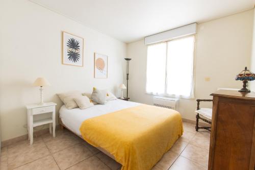 a bedroom with a bed with a yellow blanket on it at Gozzi in Ajaccio