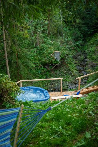 a hammock with a hot tub in the woods at Zagroda Krowiarki Chochołów in Chochołów