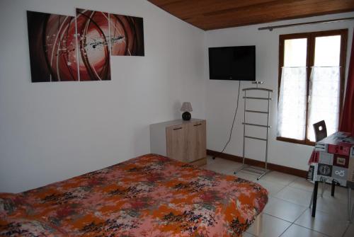 a bedroom with a bed and a flat screen tv at Le Perchoir in Rouffignac