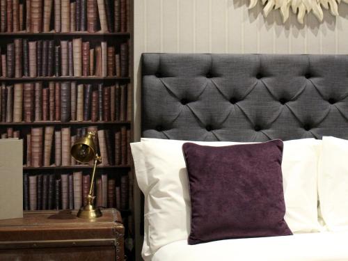 a bedroom with a bed and a book shelf with books at The One Tun Pub & Rooms in London