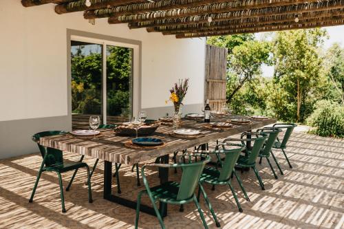 una larga mesa de madera y sillas en un patio en The ONE - Country House, en Grândola