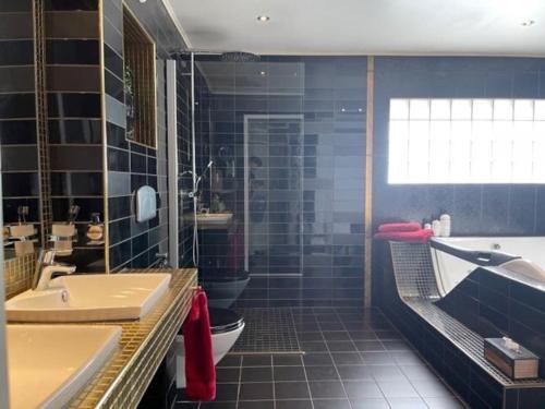 a bathroom with a tub and a toilet and a sink at Villa a Hovås con molti comfort in Hovås