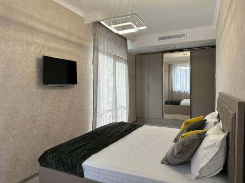 a bedroom with a bed with a television on the wall at Apt with Terrace to chill and Mountain View in Tsaghkadzor