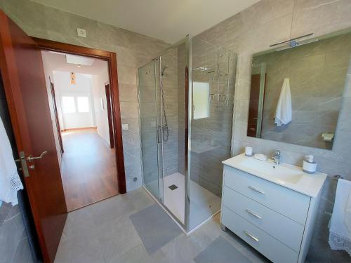 a bathroom with a shower and a sink and a mirror at Bahia de Ezaro, Costa da Morte in Dumbría