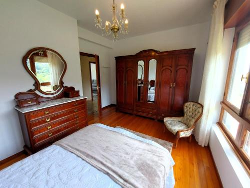 a bedroom with a bed and a dresser and a mirror at Bahia de Ezaro, Costa da Morte in Dumbría