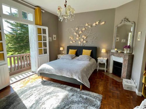 1 dormitorio con 1 cama con chimenea y espejo en Le Clos des Pommiers en Blainville-sur-Mer