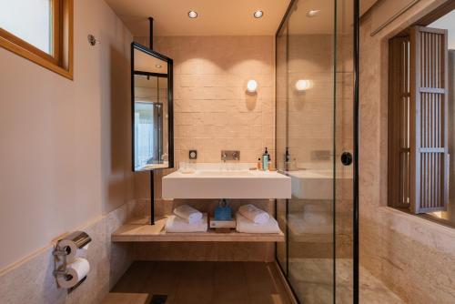 a bathroom with a sink and a glass shower at Lindos Mare, Seaside Hotel in Líndos