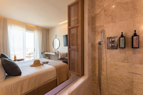 a bedroom with a shower and a bed and a bathroom at Lindos Mare, Seaside Hotel in Líndos