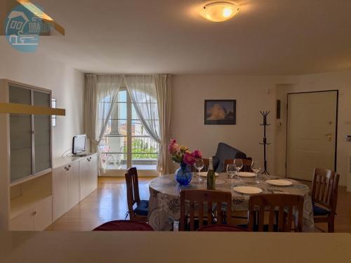 a kitchen and dining room with a table with flowers on it at Cattedrale 5 Tirabora Short Rent in Trieste