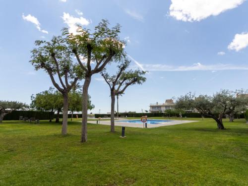 a park with trees and a swimming pool at Apartment Viena 3 by Interhome in L'Ampolla