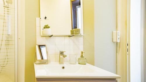 a bathroom with a white sink and a mirror at L'Atelier Colombage Bar-sur-Seine in Bar-sur-Seine