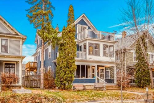 a large white house with a porch at Treetop Apartment in the Heart of MPLS in Minneapolis