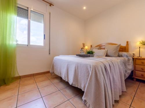 a bedroom with a bed with a white blanket and a window at Villa Imma by Interhome in L'Eucaliptus