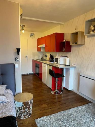 - une petite cuisine avec des placards rouges et un comptoir dans l'établissement Studio aux pieds des montagnes, à Bourg-Saint-Maurice