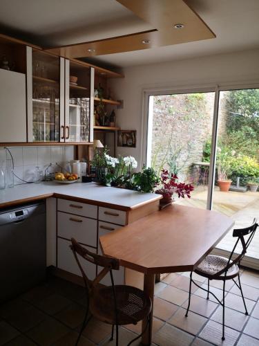 une cuisine avec une table et des chaises et une fenêtre dans l'établissement Maison centre ville avec jardin, à Concarneau