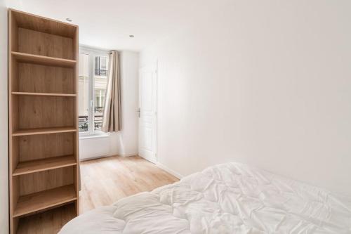une chambre avec un lit et une étagère dans l'établissement Appartement cosy canal Saint Martin, à Paris