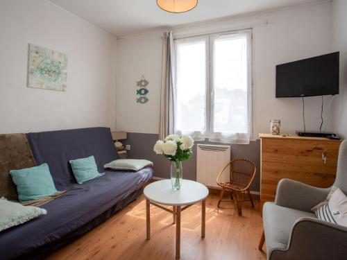 - un salon avec un canapé et une table ornée d'un vase de fleurs dans l'établissement Holiday Home L'Adalou by Interhome, à Pornic