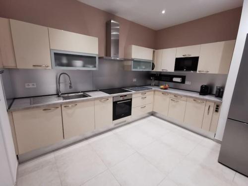 une grande cuisine avec des armoires et des appareils blancs dans l'établissement Villa vue mer proche mer 10 personnes, à Saint-Raphaël