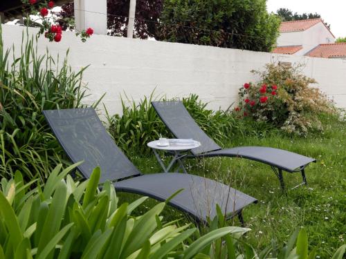 2 chaises et une table dans l'herbe dans l'établissement Holiday Home L'Adalou by Interhome, à Pornic