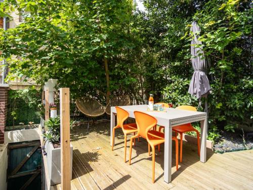une table et des chaises blanches sur une terrasse en bois dans l'établissement Holiday Home La Trouvillaise by Interhome, à Trouville-sur-Mer