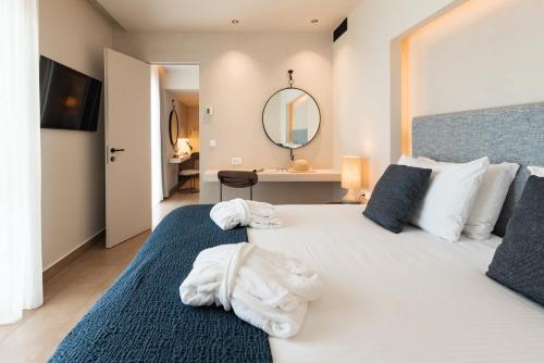 a bedroom with a large bed with towels on it at Lindos Mare, Seaside Hotel in Líndos
