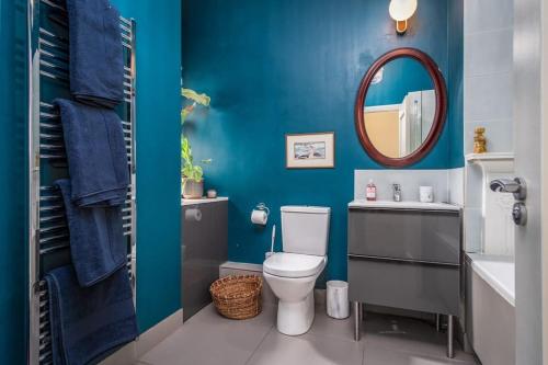 a blue bathroom with a toilet and a mirror at The Chancery in Dublin