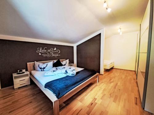 a bedroom with a bed with a black wall at Apartment Kröll beim Geislerhof by Interhome in Ramsau