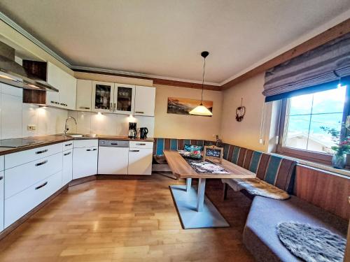 a kitchen with a wooden table and a dining room at Apartment Kröll beim Geislerhof by Interhome in Ramsau