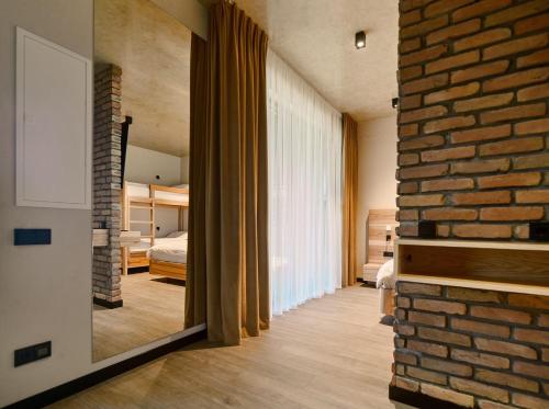 a room with a brick wall and a mirror at Black Sea Resort in Primorskoye