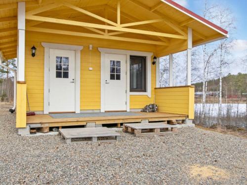 a yellow house with white doors and a porch at Holiday Home Kaislajärven huvila by Interhome in Risulahti
