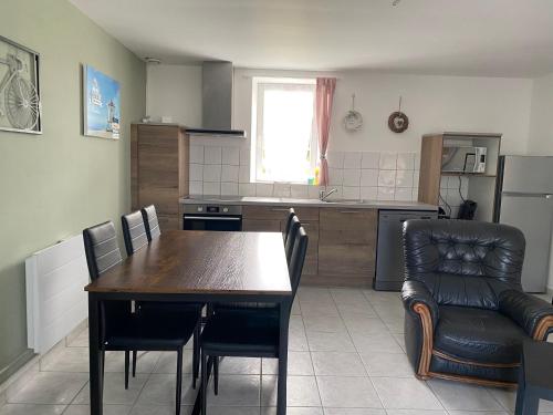 - une cuisine avec une table et des chaises en bois dans l'établissement Appartement 2 chambres et cuisine-salon Plages du Débarquement, à Vierville-sur-Mer