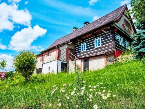 an old wooden house on a hill with flowers at Holiday Home Na kopečku by Interhome in Tanvald