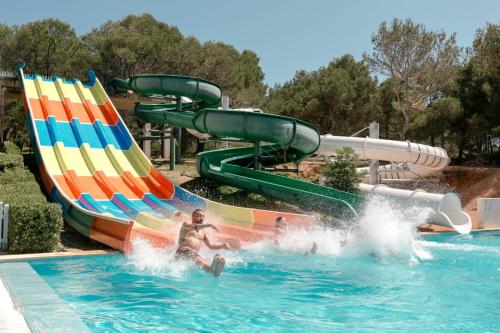 a group of people in a water slide at a water park at Club Hotel Aguamarina in Arenal d'en Castell