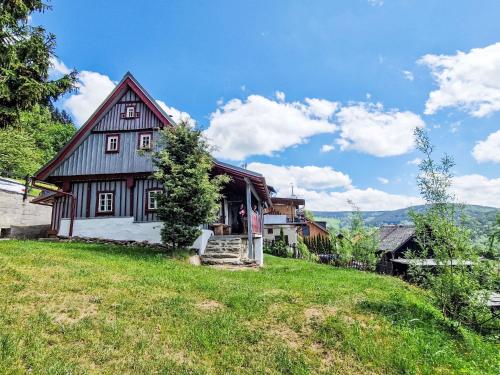 a large wooden house on a grassy hill at Holiday Home Jizerka by Interhome in Tanvald