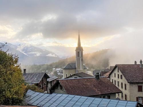 a view of a town with a church and mountains at Apartment Panorama da muntognas by Interhome in Trin