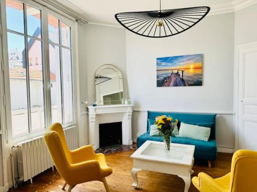- un salon avec un canapé bleu et des fauteuils jaunes dans l'établissement Villa Pomponnette, à La Baule