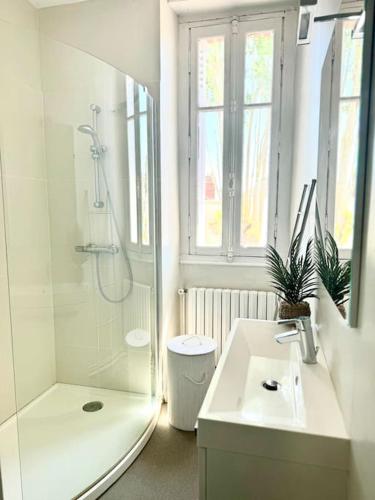une salle de bain blanche avec une douche et un lavabo dans l'établissement Villa Pomponnette, à La Baule