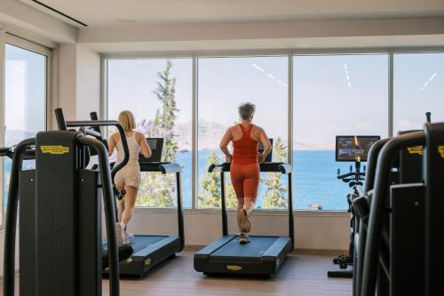 two women running on treadmills in a gym at Lindos Mare, Seaside Hotel in Líndos
