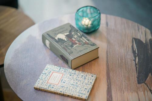 a table with a book and a candle on top of it at Motel One Lübeck in Lübeck